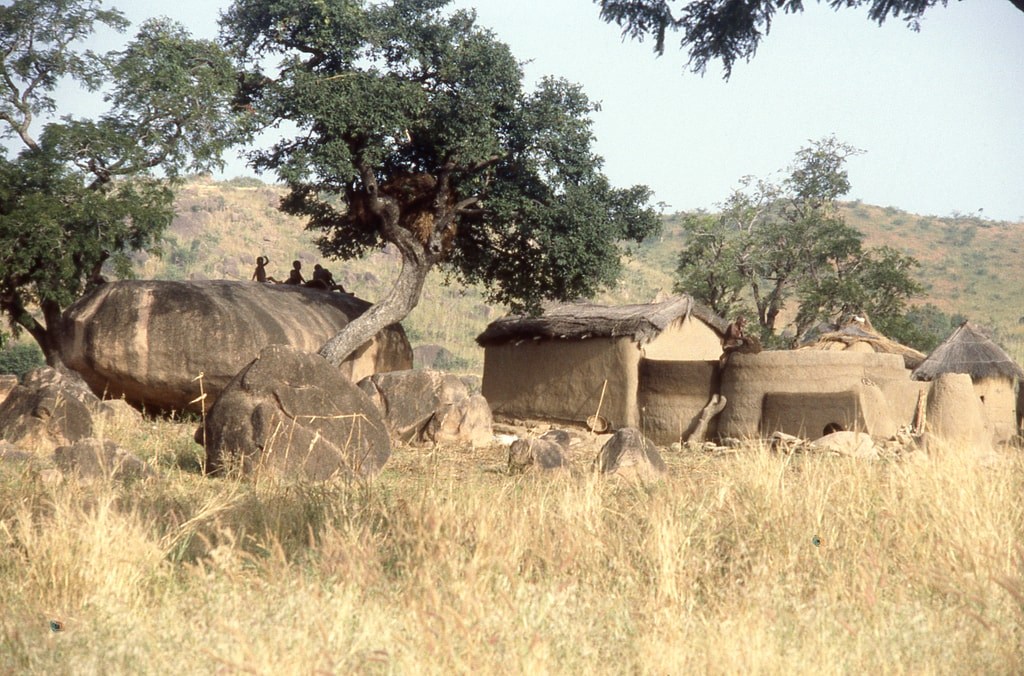 Children on a rock outside a house