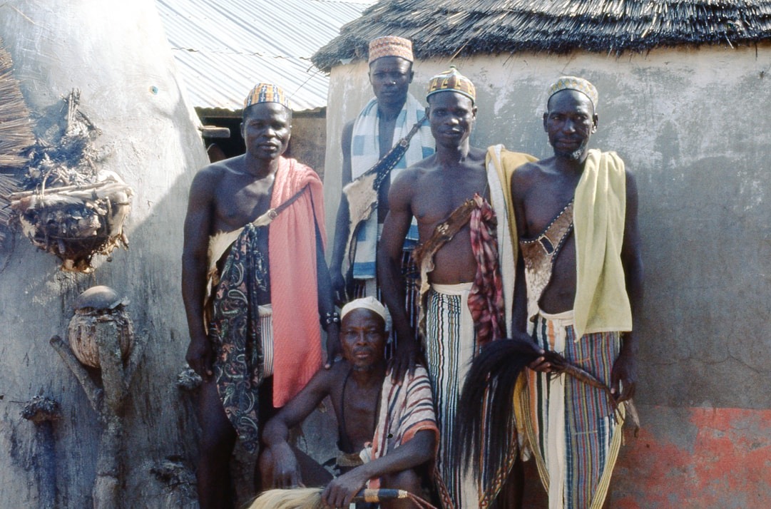 Men and a sacrificial shrine outside a house